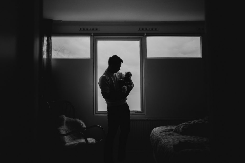 Vader die baby vasthoudt voor raam